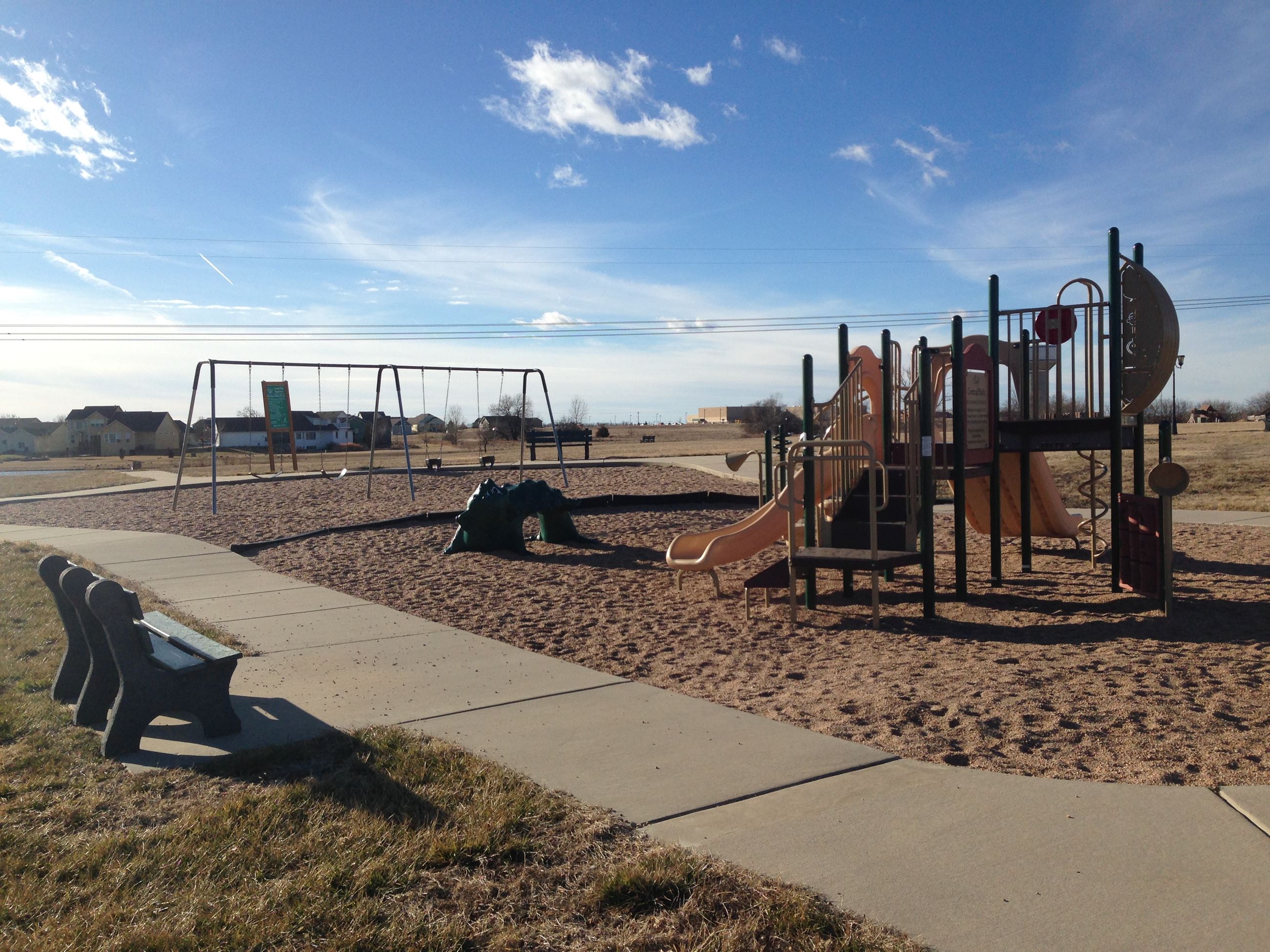 Central Park play equipment with swing set in the background